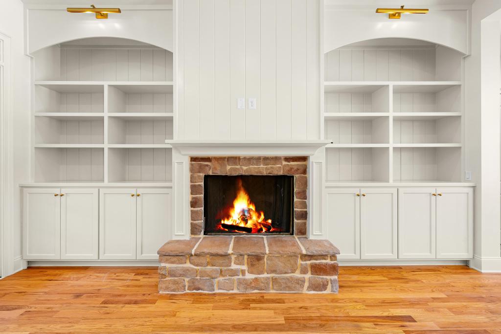 707 Vickery Street Extension Hartwell, GA 30643 - Photo 6 of 50 A robust stone fireplace is flanked by custom built-in shelving, creating a focal point in this inviting space.