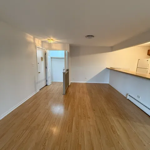 a view of empty room with wooden floor
