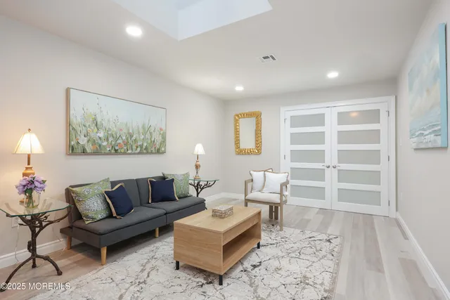 a living room with furniture and a painting on the wall