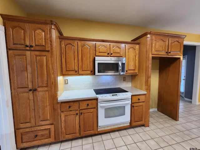 a kitchen with stainless steel appliances a refrigerator stove and cabinets