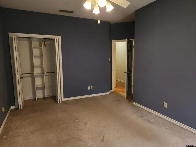 an empty room with windows and closet