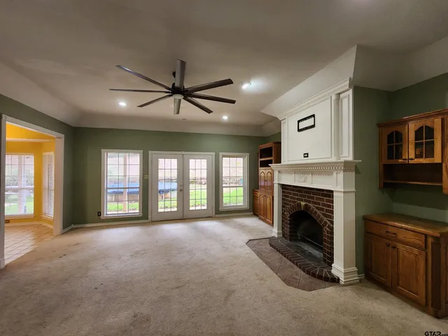 a view of an empty room with a fireplace and a window