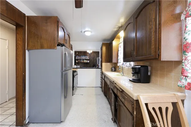 a kitchen with a refrigerator a sink and cabinets