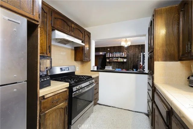 a kitchen with stainless steel appliances a refrigerator and a stove top oven