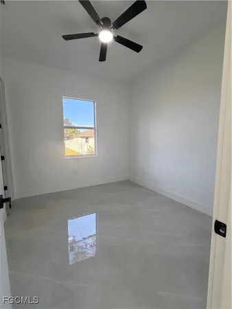 an empty room with chandelier fan