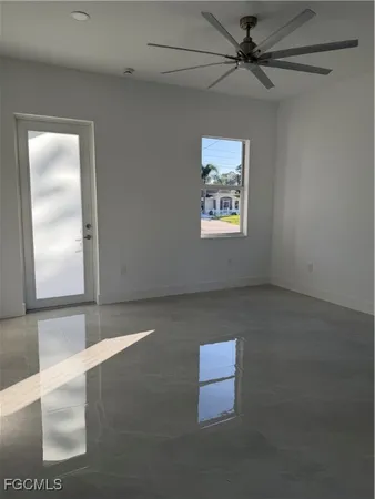 an empty room with windows and fan