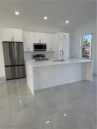 a large kitchen with stainless steel appliances a refrigerator and a stove top oven