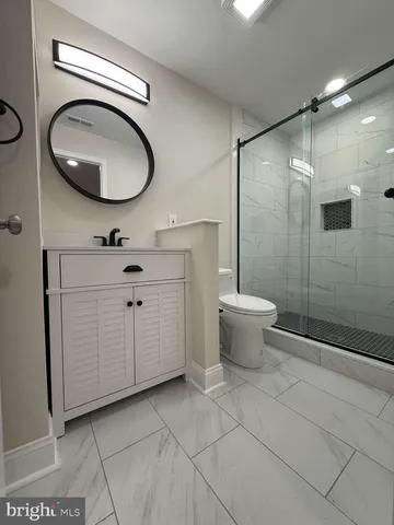 a bathroom with a toilet a sink and mirror