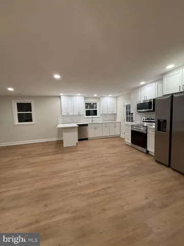 a large kitchen with a stove a refrigerator and a kitchen island