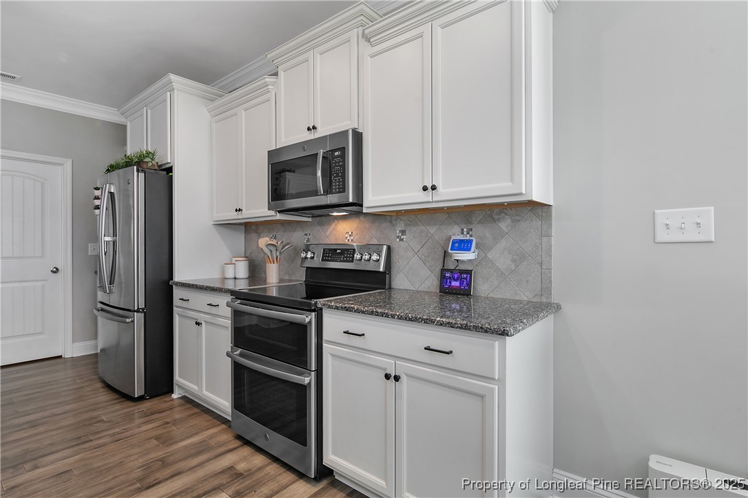2628 Riddle Farm Road Hope Mills, NC 28348 - Photo 21 of 50 a kitchen with stainless steel appliances granite countertop a refrigerator sink and stove