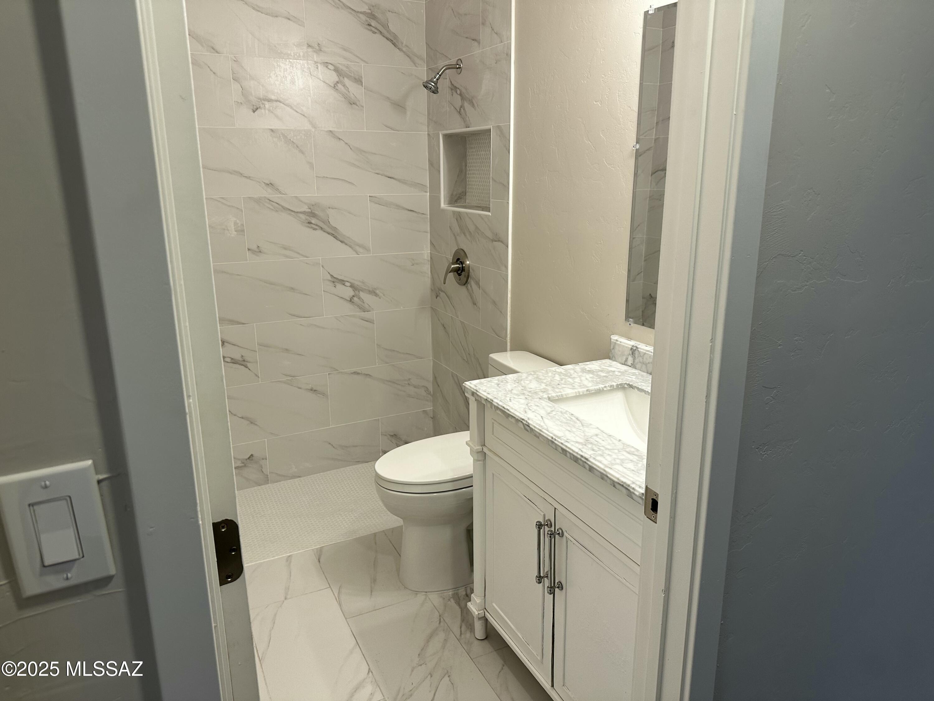 645 East Mabel Street Tucson, AZ 85705 - Photo 15 of 22 a bathroom with a granite countertop sink a toilet and shower