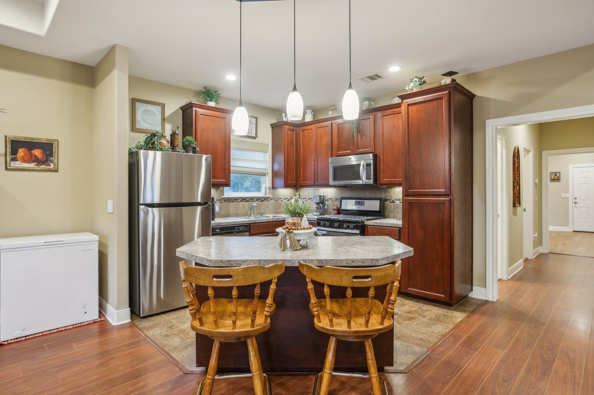 198 Kelley Road East Bastrop, TX 78602 - Photo 14 of 40 a kitchen with stainless steel appliances a dining table chairs refrigerator and sink