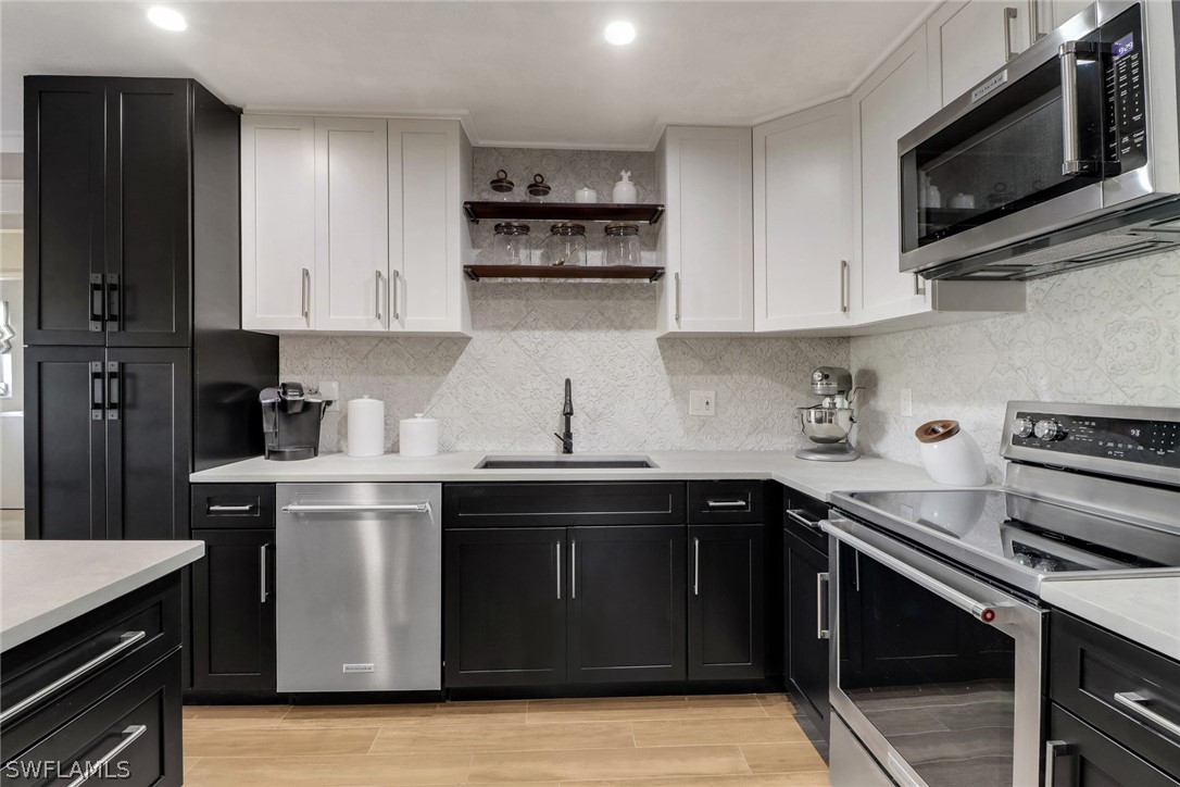 2574 Bayshore Drive Matlacha, FL 33993 - Photo 18 of 43 a kitchen with stainless steel appliances a stove microwave and sink