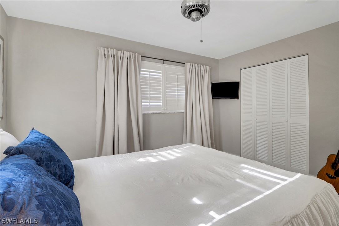 2574 Bayshore Drive Matlacha, FL 33993 - Photo 28 of 43 a bedroom with a large bed and a chandelier fan