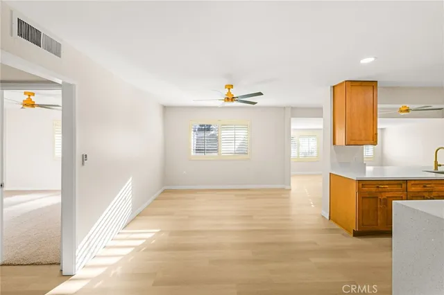an empty room with a window and a fan