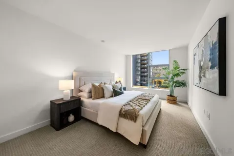 a bedroom with bed and a large window