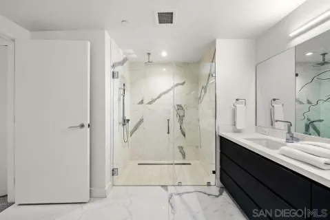 a bathroom with a double vanity sink mirror and shower