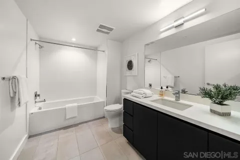 a bathroom with a sink double vanity mirror and a bathtub