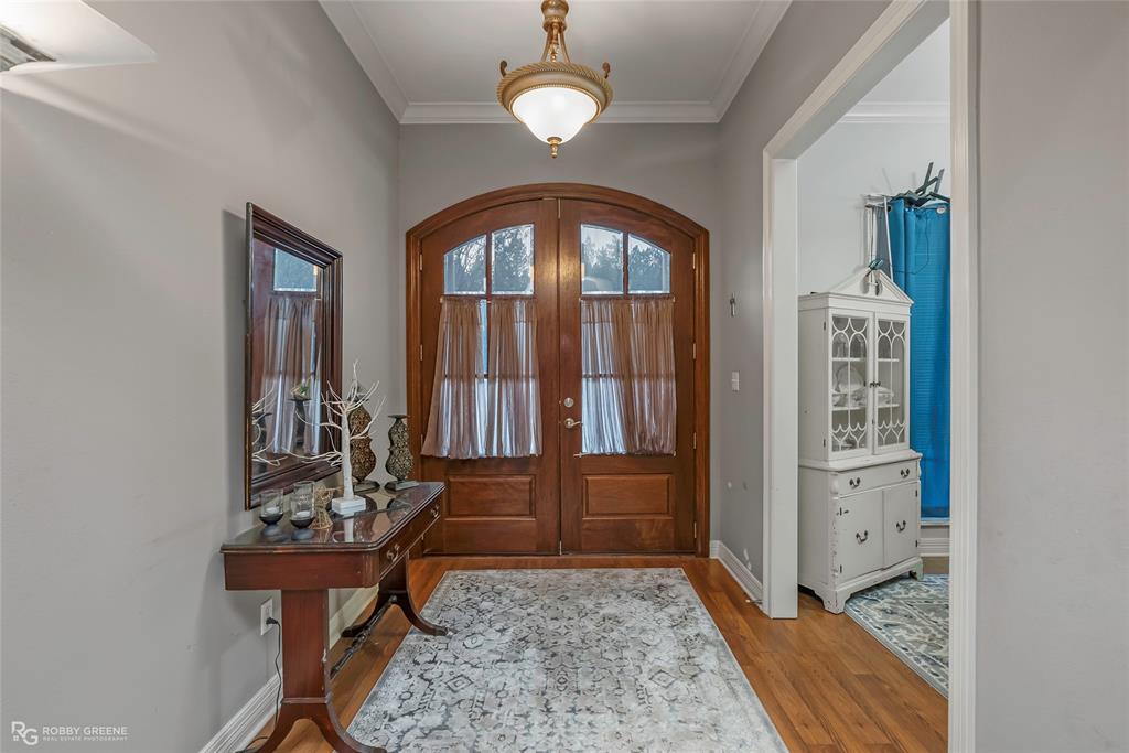 12168 Highway 157 Princeton, LA 71067 - Photo 12 of 32 Foyer featuring ornamental molding, french doors, plenty of natural light, and wood finished floors