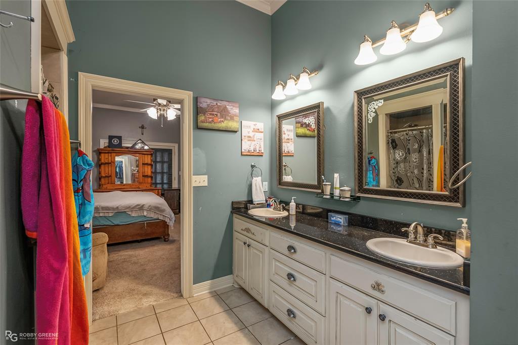 12168 Highway 157 Princeton, LA 71067 - Photo 30 of 32 Ensuite bathroom with light tile patterned floors, double vanity, light carpet, ornamental molding, and a shower with shower curtain