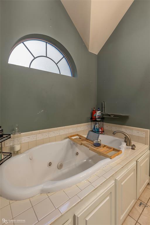 12168 Highway 157 Princeton, LA 71067 - Photo 31 of 32 Full bath featuring healthy amount of natural light, a tub with jets, light tile patterned floors, and lofted ceiling