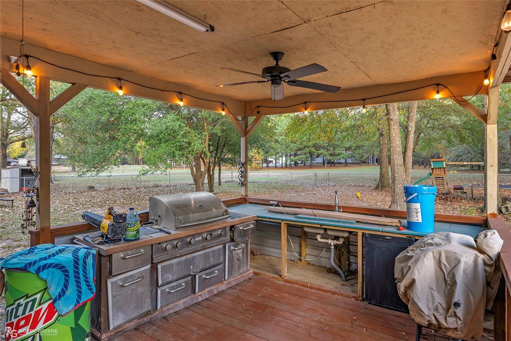 12168 Highway 157 Princeton, LA 71067 - Photo 5 of 32 View of patio / terrace featuring an outdoor kitchen, a ceiling fan, and a deck
