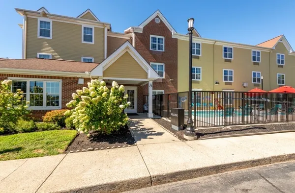 a front view of a house with a yard and potted plants
