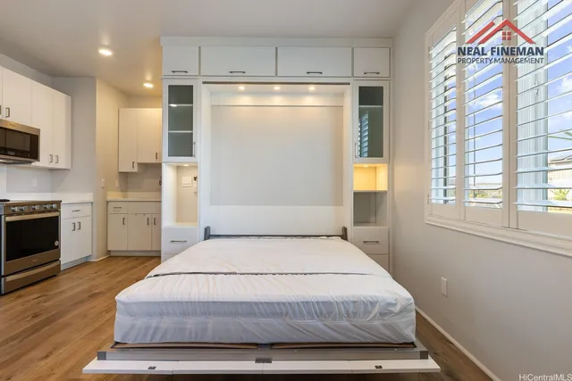 a bedroom with a bed and a refrigerator