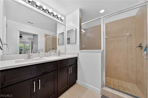 a bathroom with a double vanity sink mirror and shower
