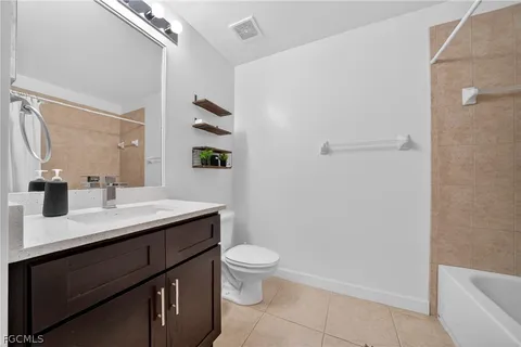 a bathroom with a sink a toilet a mirror and shower