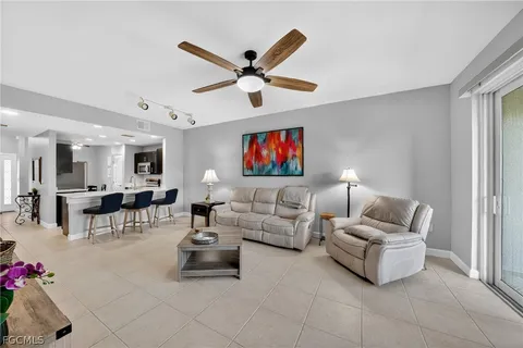 a living room with furniture and a ceiling fan