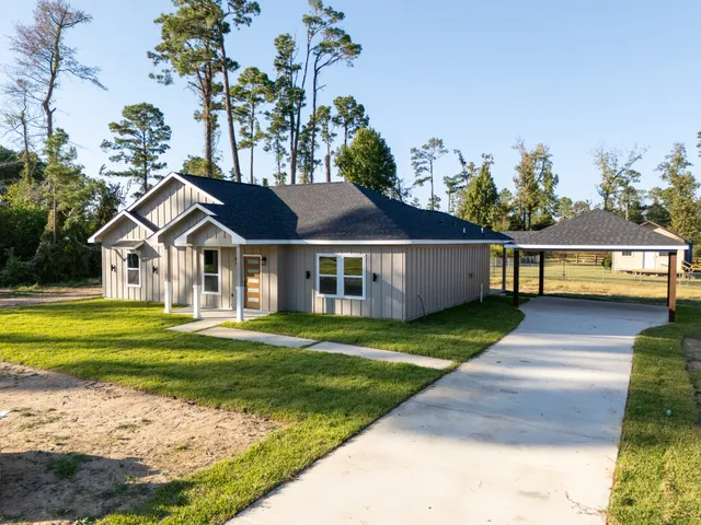 a front view of a house with a garden and yard
