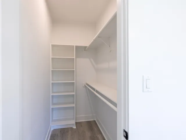 a view of walk in closet with empty racks