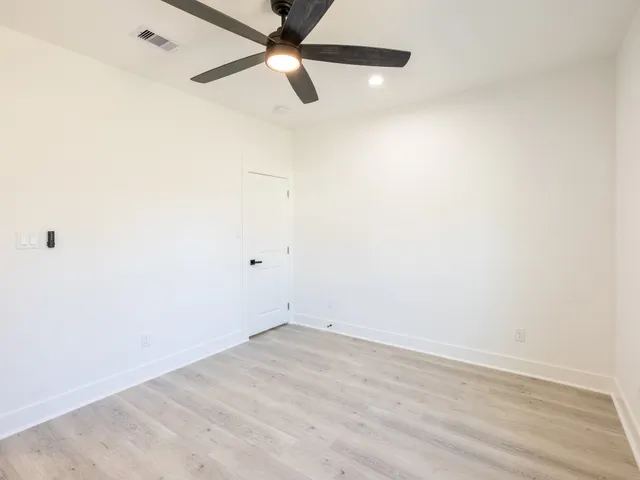an empty room with a window and a fan
