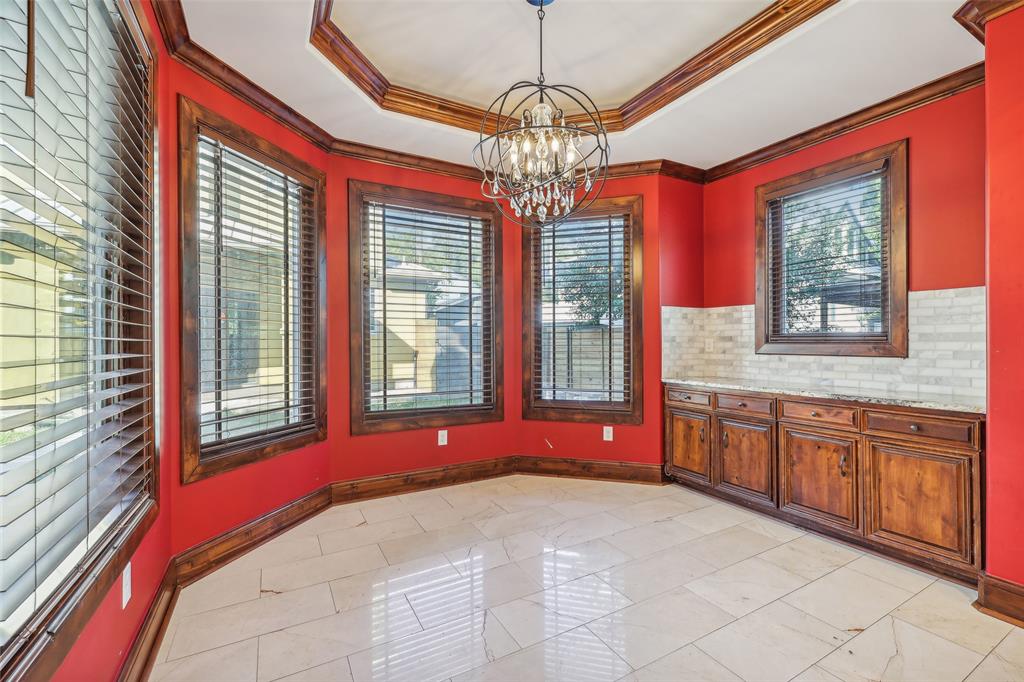 1904 East 13th Street, Unit A Austin, TX 78702 - Photo 12 of 27 Unfurnished dining area with a raised ceiling, healthy amount of natural light, ornamental molding, and a chandelier