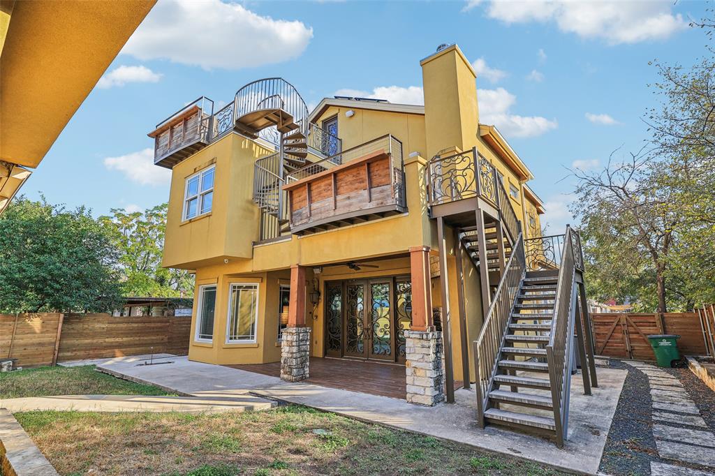1904 East 13th Street, Unit A Austin, TX 78702 - Photo 23 of 27 Back of property with stairs, a fenced backyard, stucco siding, a chimney, and a patio area