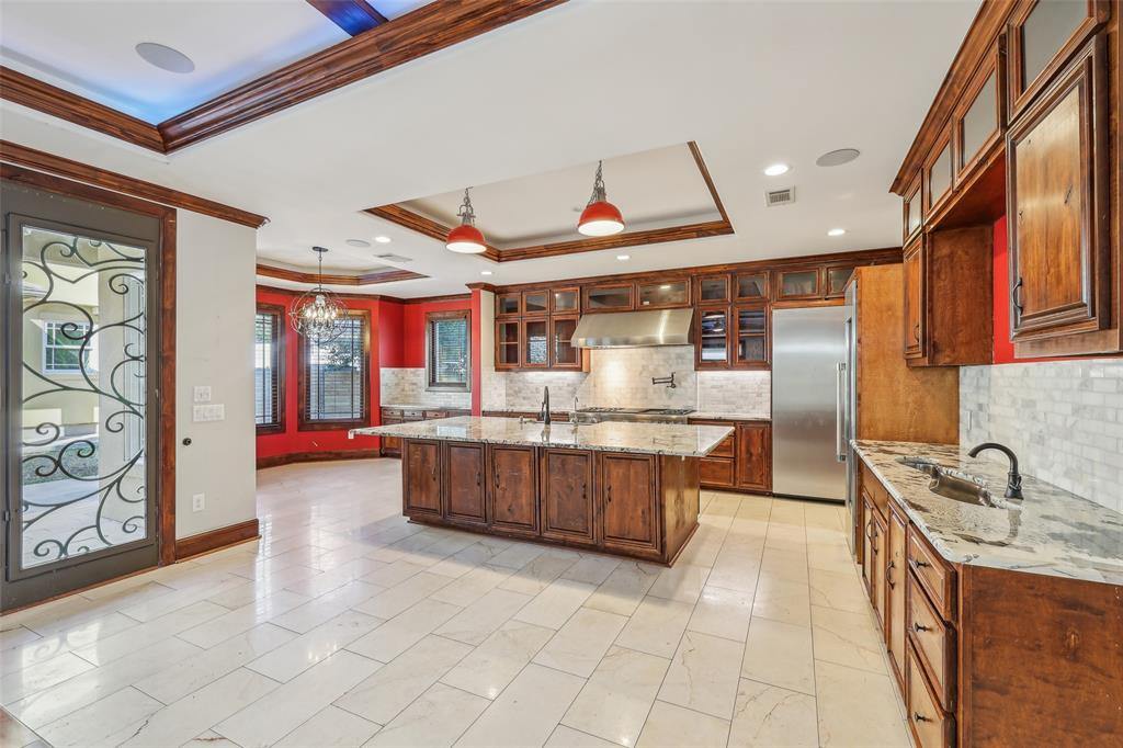 1904 East 13th Street, Unit A Austin, TX 78702 - Photo 7 of 27 Kitchen featuring a raised ceiling, glass insert cabinets, light stone countertops, a chandelier, and hanging light fixtures