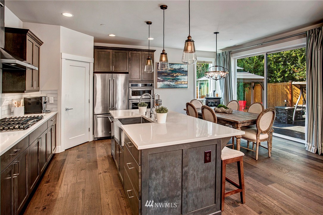 22326 9th Drive Southeast Bothell, WA 98021 - Photo 8 of 40 a kitchen with stainless steel appliances granite countertop a stove a refrigerator a kitchen island a dining table and chairs