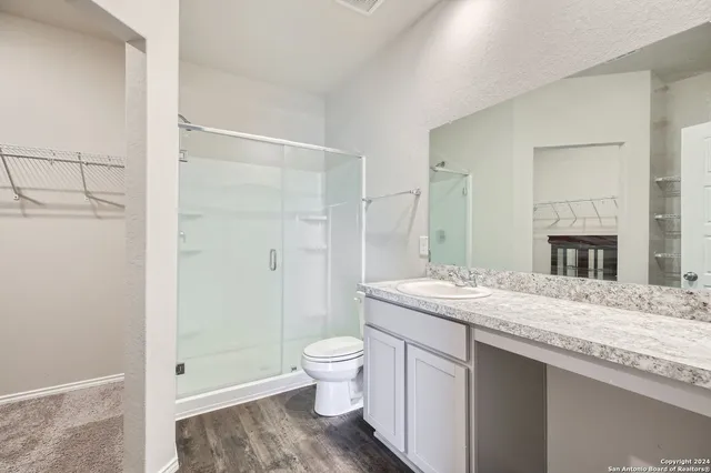 a bathroom with a granite countertop sink toilet and shower