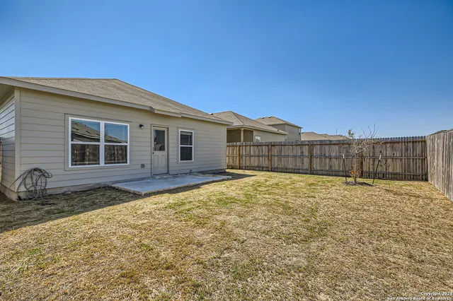 a view of a house with a wooden fence