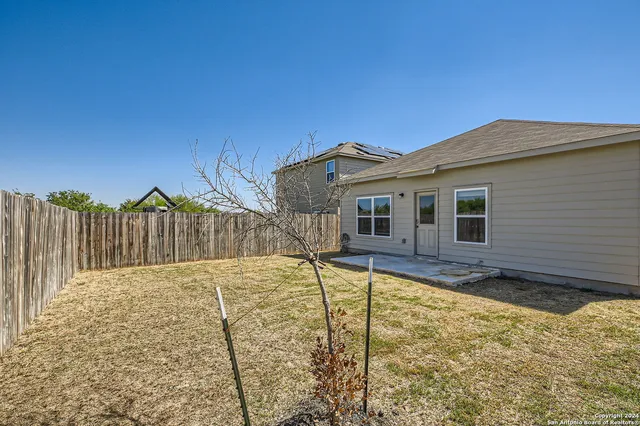 a view of a backyard with wooden fence