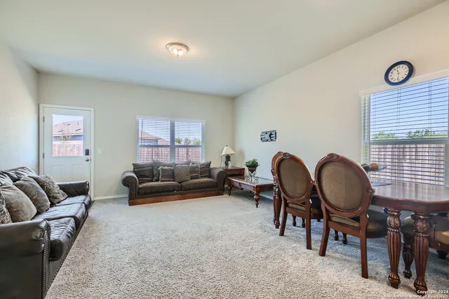 a living room with furniture a rug and a window