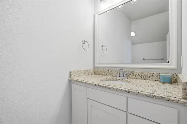 a bathroom with a granite countertop sink and a mirror