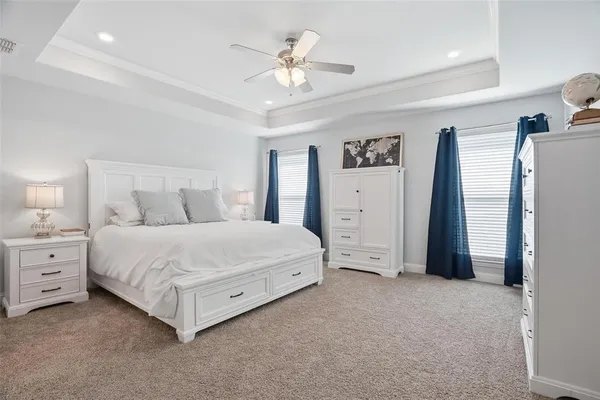 a spacious bedroom with a bed and a chandelier