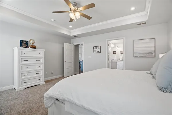 a spacious bedroom with a bed and a chandelier
