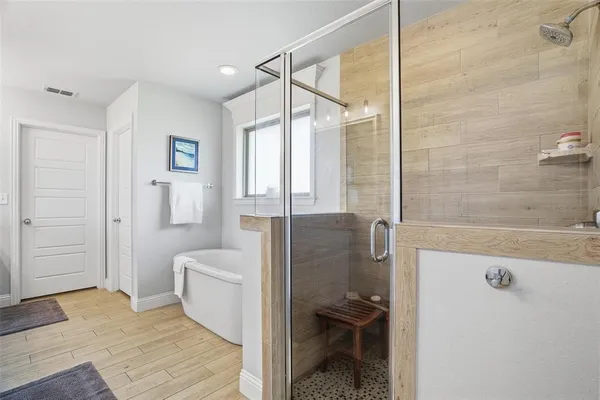 a bathroom with a tub sink mirror and shower