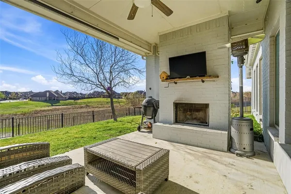 a view of a patio with a tv sofas fire pit and outdoor seating