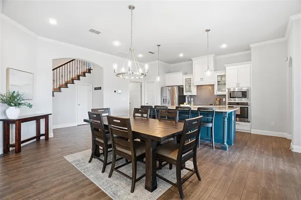 a view of a dining room and livingroom with furniture wooden floor a chandelier