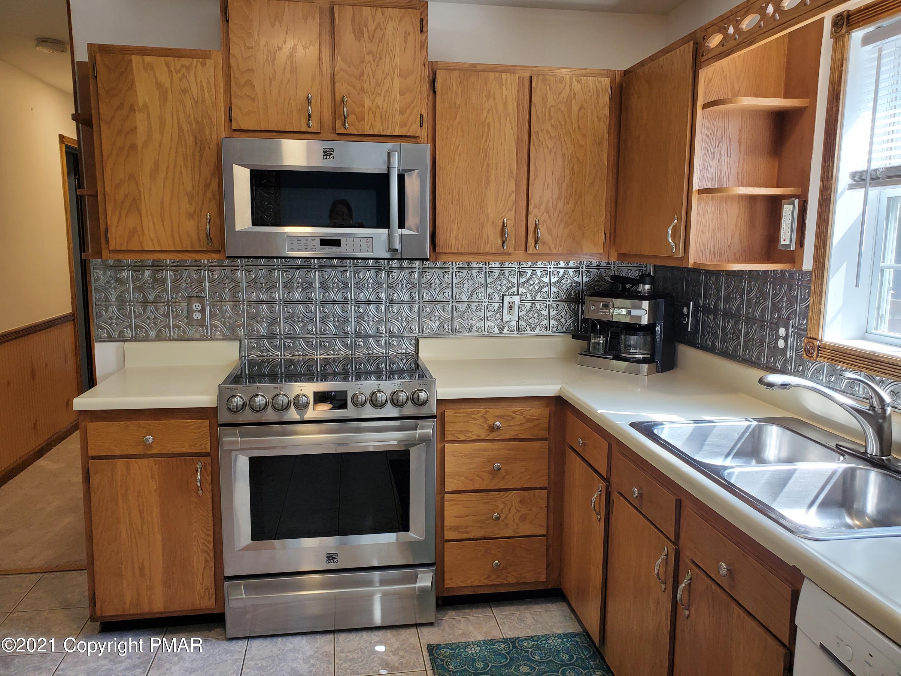 284 Powder Horn Road Henryville, PA 18332 - Photo 8 of 42 a kitchen with granite countertop a sink stove and microwave