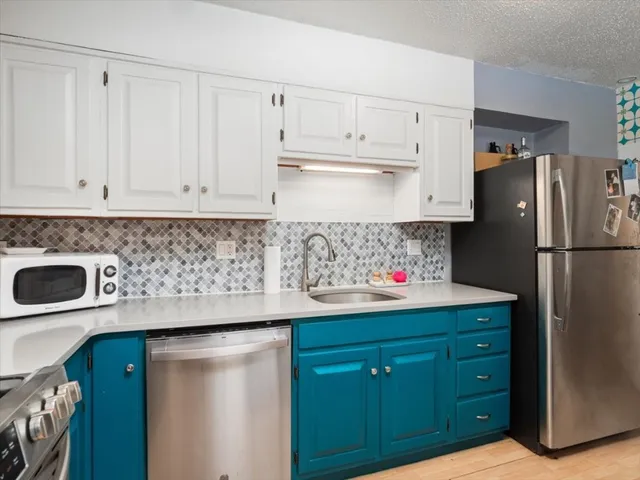a kitchen with stainless steel appliances white cabinets and a refrigerator